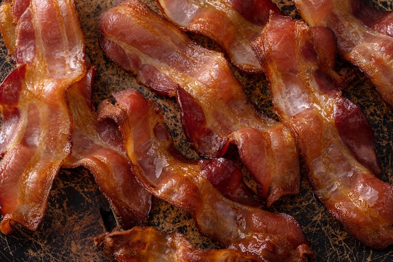 Cooked bacon on a serving platter. Photo via Shutterstock.