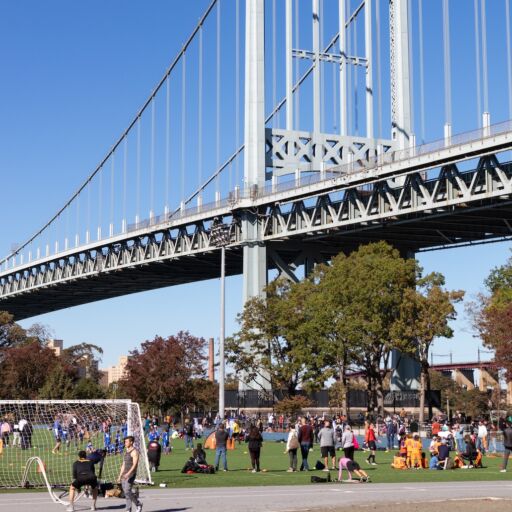 Astoria, Queens USA - October 17 2020: Athletic Field at Astoria Park Filled with People and the Triborough Bridge in Astoria Queens New York