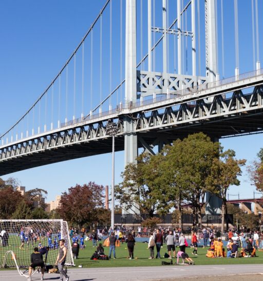 Astoria, Queens USA - October 17 2020: Athletic Field at Astoria Park Filled with People and the Triborough Bridge in Astoria Queens New York