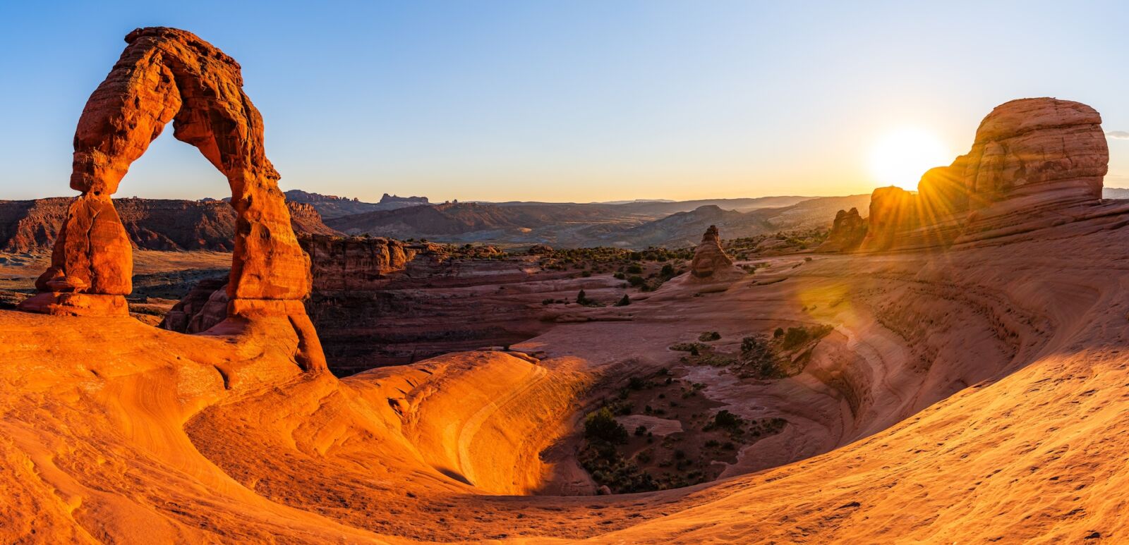 Delicate Arch - The most famous landmark of the Arches National Park in Utah in strong sunlight during sunset.